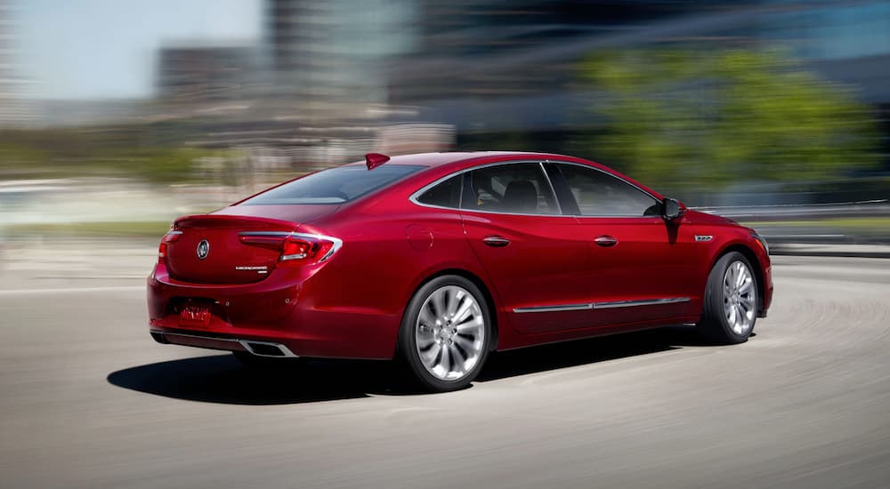 Rear view of a red 2019 Buick LaCrosse driving down an open road.