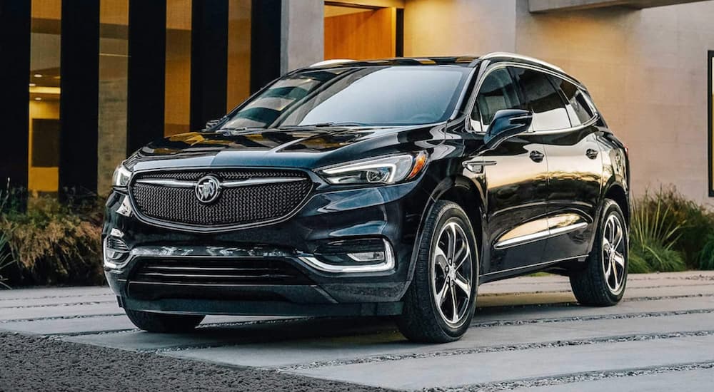 A black 2021 Buick Enclave parked on a driveway after visiting a dealer with used cars for sale.