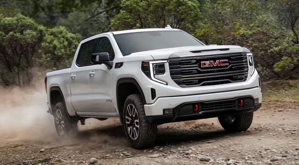 A white 2025 GMC Sierra 1500 AT4 off-roading.