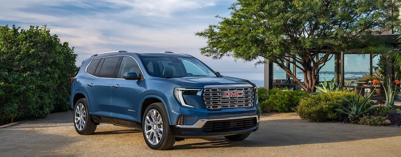 Blue 2026 GMC Acadia Denali parked on a driveway.