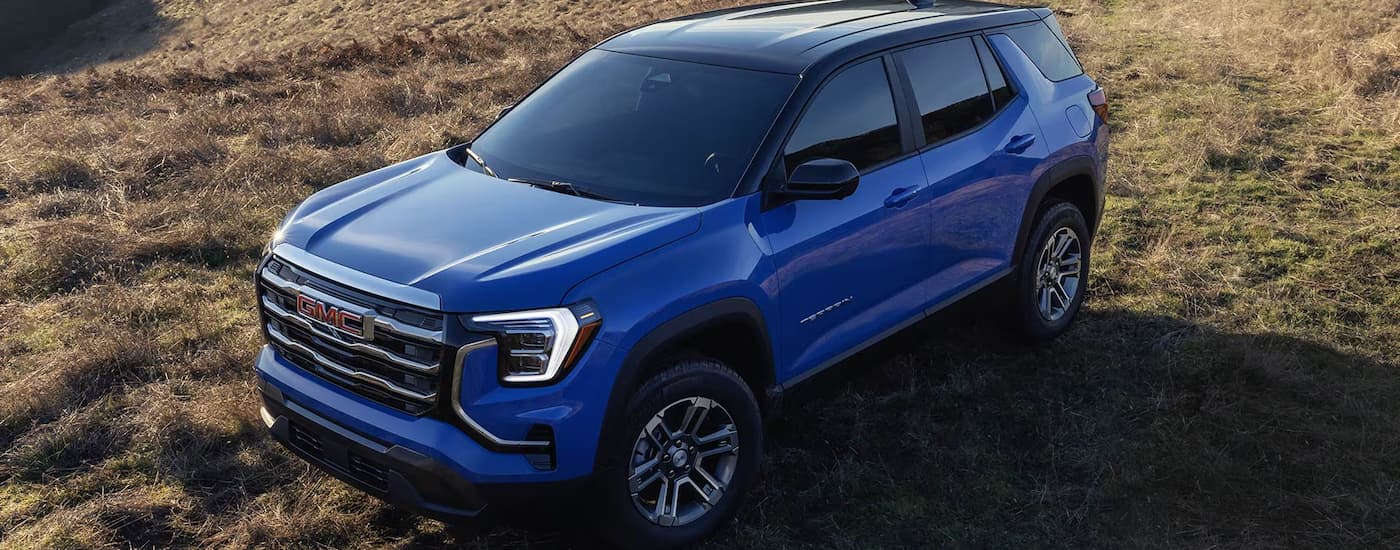 Blue 2026 GMC Terrain parked on a dry grassy field