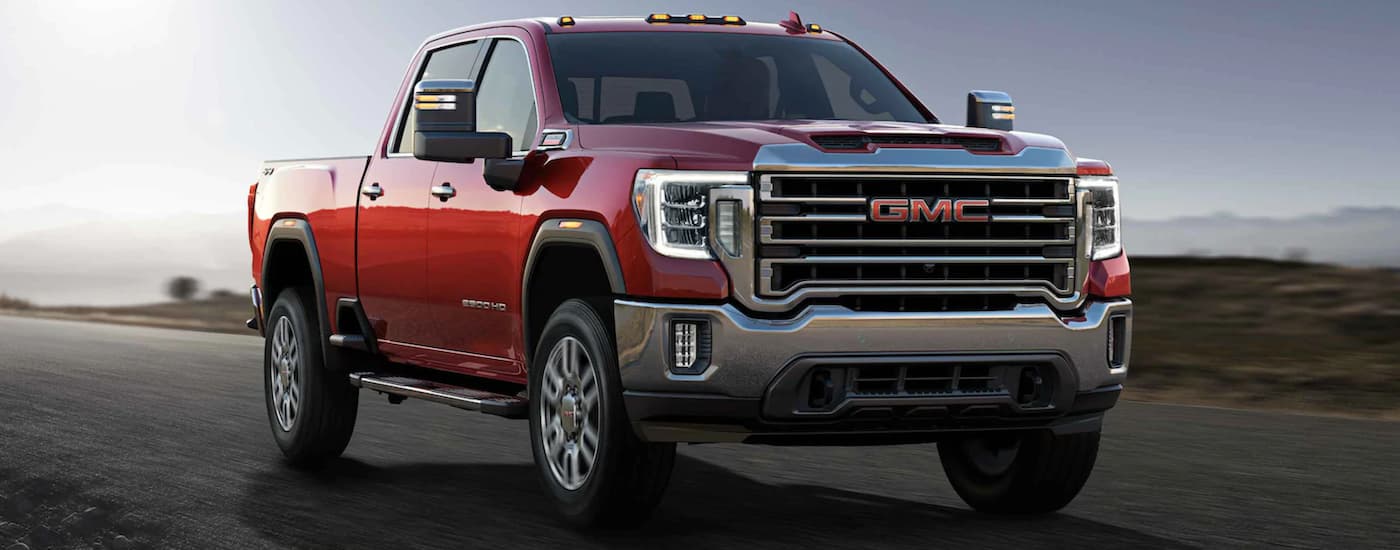 A red 2021 GMC Sierra 2500 HD driving.