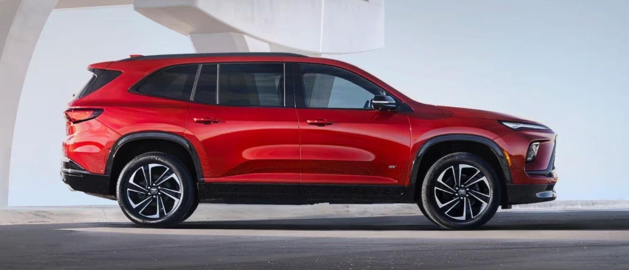 A red 2025 Buick Enclave ST is shown from the side after leaving a Buick dealer.