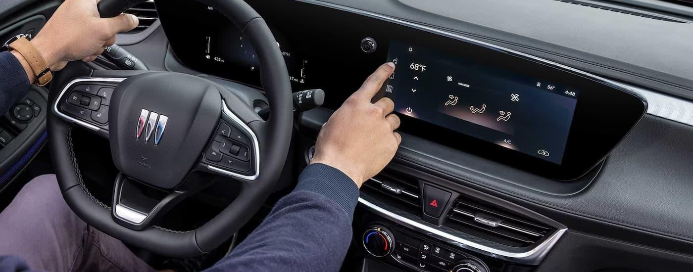 A person is using the infotainment screen in a 2025 Buick Encore GX.
