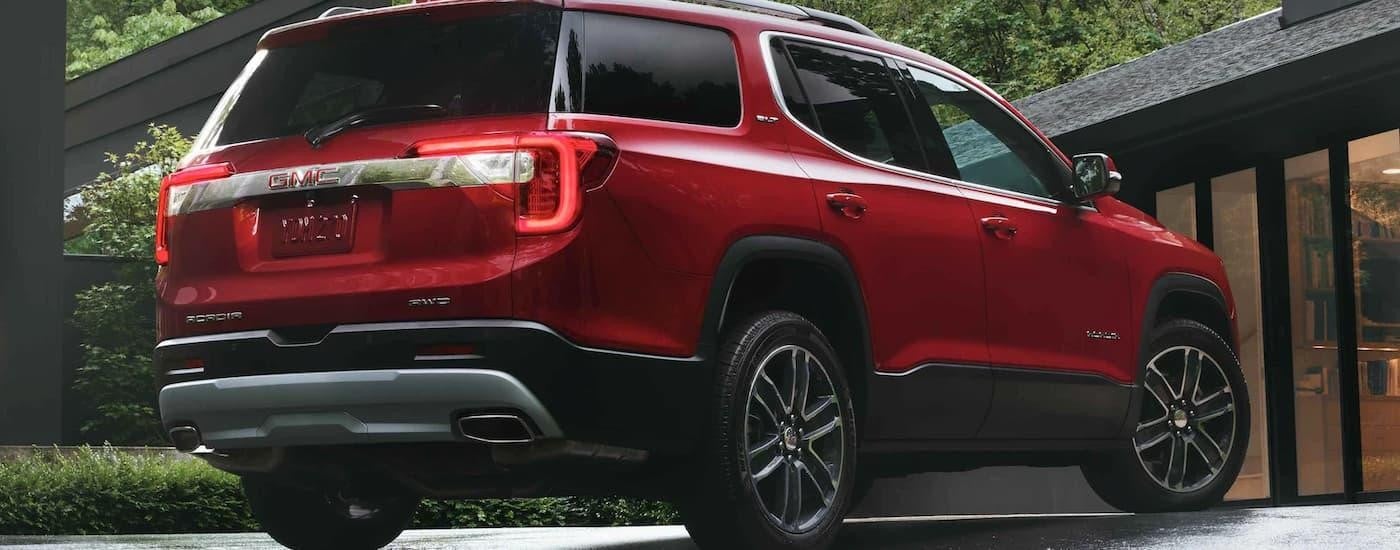 A red 2022 GMC Acadia is parked in a driveway on a foggy day.