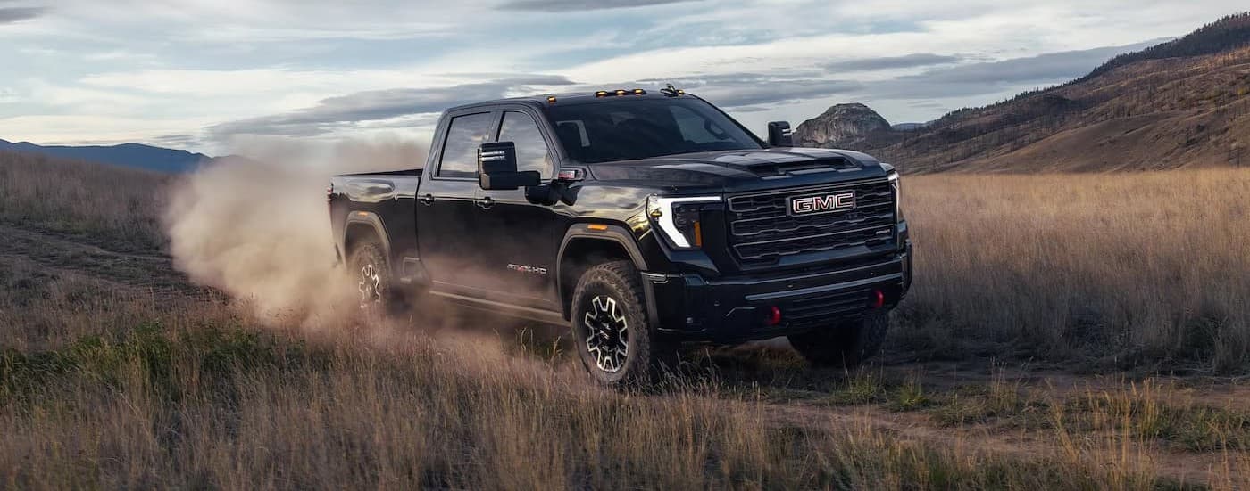 A black 2026 GMC Sierra 2500 AT4X off-roading.