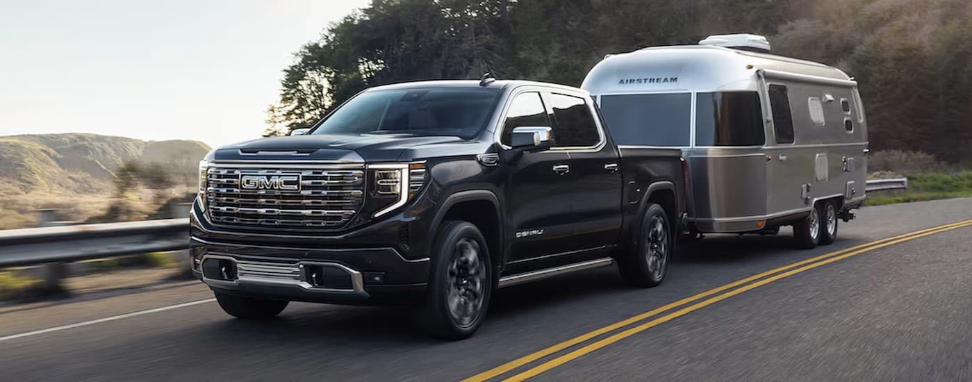 A black 2025 GMC Sierra 1500 towing a trailer.