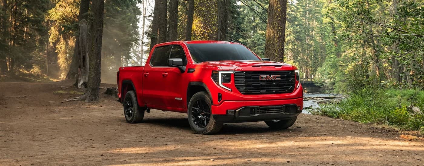 A red 2026 GMC Sierra 1500 parked in a forest.