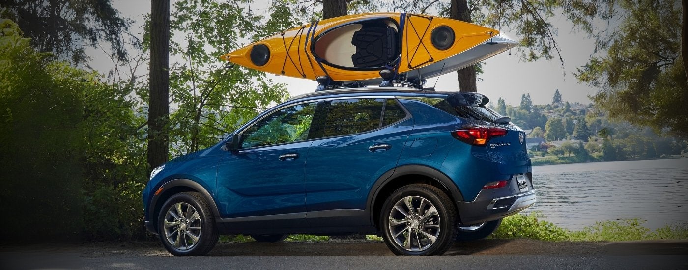 A blue 2020 Buick Encore GX is parked near a lake.