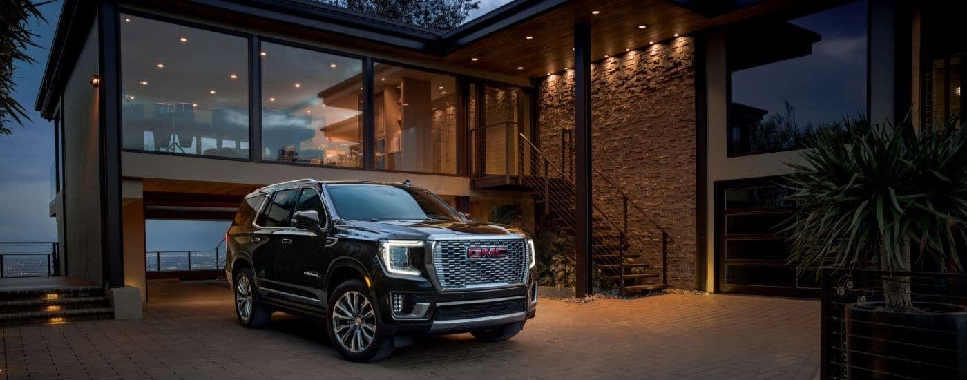 A black 2023 GMC Yukon Denali parked on a driveway.
